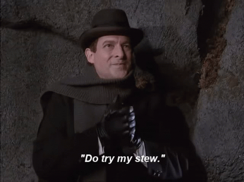 A Man Wearing A Hat And Gloves Says " Rubs Hands With Anticipation " GIF