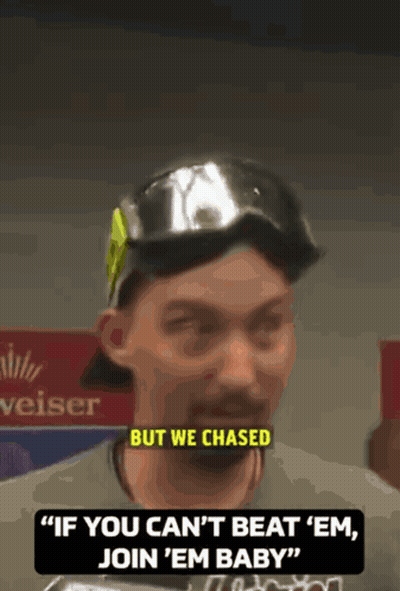A Man Wearing A Hat And Goggles Says " If You Can 'T Beat ' Em Join ' Em Baby " GIF