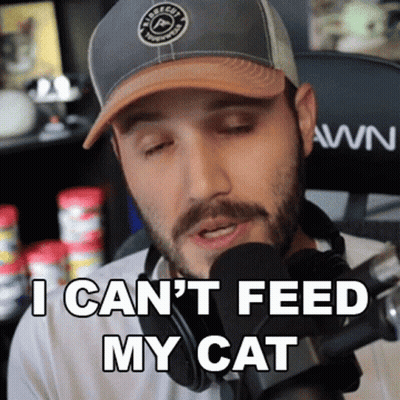 A Man Wearing A Hat And Headphones Says I Can T Feed My Cat GIF