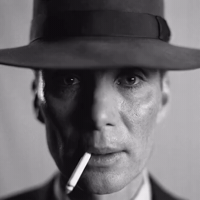 A Man Wearing A Hat And Smoking A Cigarette In A Black And White Photo . GIF