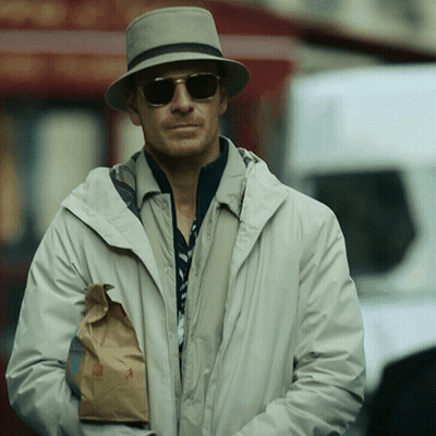 A Man Wearing A Hat And Sunglasses Is Holding A Bag Of Food GIF