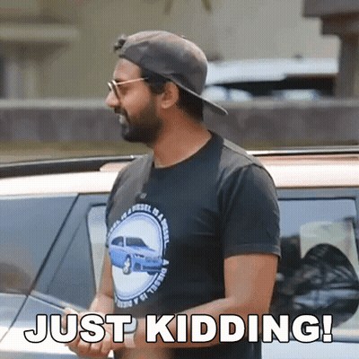 A Man Wearing A Hat And Sunglasses Is Standing In Front Of A Car And Says Just Kidding ! GIF