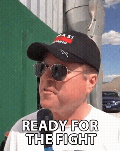 A Man Wearing A Hat And Sunglasses Is Talking Into A Microphone And Saying Ready For The Fight . GIF