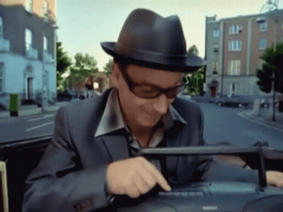 A Man Wearing A Hat And Sunglasses Is Using A Keyboard GIF