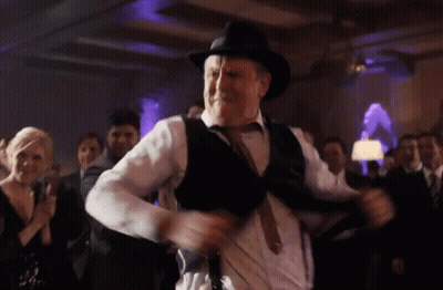 A Man Wearing A Hat And Suspenders Is Dancing At A Party GIF