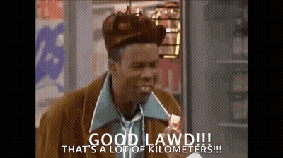 A Man Wearing A Hat And Tie Is Holding A Candy Bar And Says Good Lawd !!! GIF