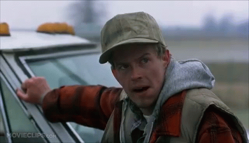 A Man Wearing A Hat And Vest Is Standing Next To A Car . GIF