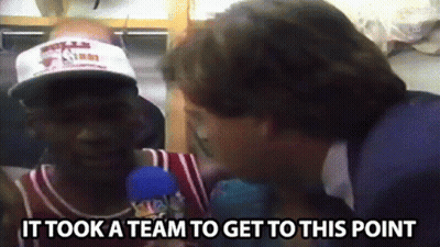 A Man Wearing A Hat Is Being Interviewed By A Man Wearing A Suit . GIF