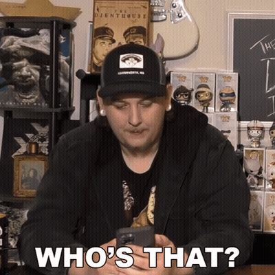 A Man Wearing A Hat Is Holding A Phone And Says Who 'S That GIF