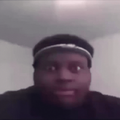 A Man Wearing A Hat Is Making A Funny Face In A Room . GIF