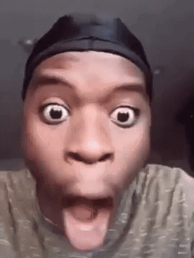 a man wearing a hat is making a funny face with his tongue hanging out .