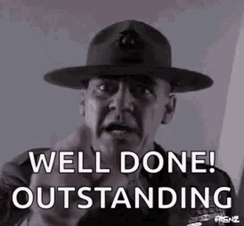 A Man Wearing A Hat Is Pointing At The Camera And Saying `` Well Done ! Outstanding '' . GIF