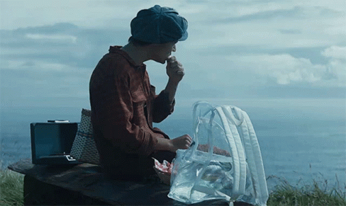 Man In Hat Sitting On Bench With Food Bag GIF