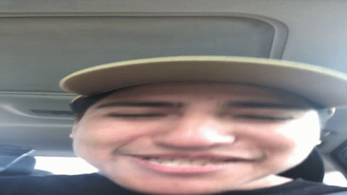 A Man Wearing A Hat Is Smiling And Looking Down GIF