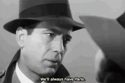 A Man Wearing A Hat Is Talking To Another Man In A Black And White Photo . GIF
