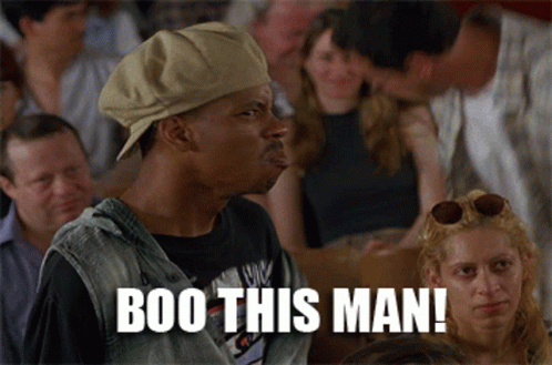 A Man Wearing A Hat Says Boo This Man In A Crowd Of People GIF