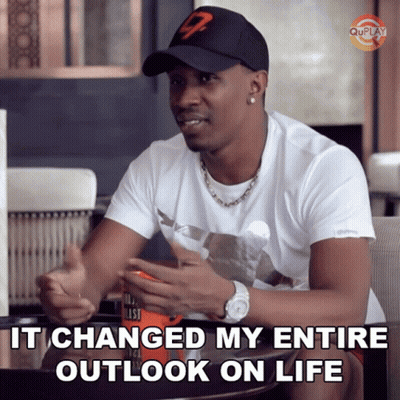 A Man Wearing A Hat Says " It Changed My Entire Outlook On Life " While Sitting At A Table GIF