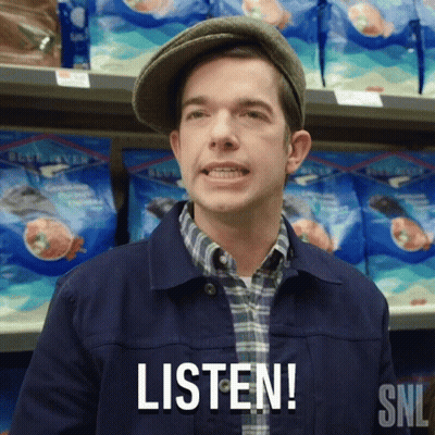 A Man Wearing A Hat Says Listen In Front Of A Shelf Of Food GIF
