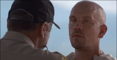 A Man Wearing A Hat That Says Brooklyn Is Touching The Neck Of Another Man GIF