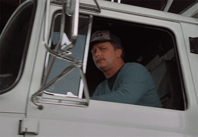 A Man Wearing A Hat That Says ' Eagle ' On It Is Sitting In The Driver 'S Seat Of A White Truck GIF
