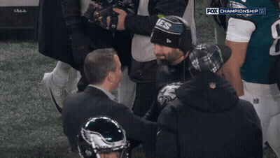 A Man Wearing A Hat That Says Eagles On It Is Surrounded By Other People GIF