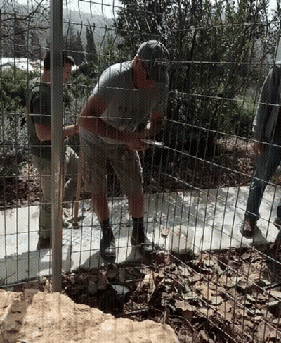 A Man Wearing A Hat That Says Fed Is Standing Behind A Wire Fence GIF