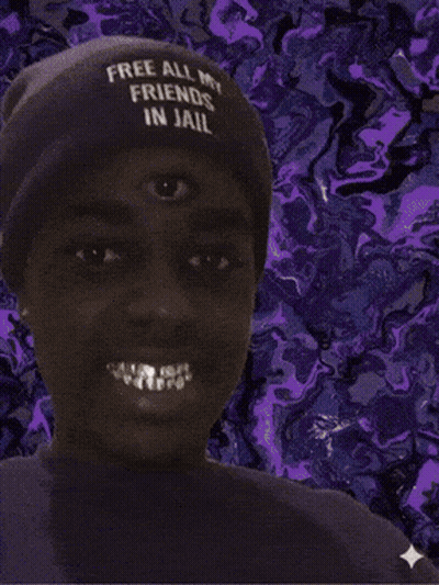 A Man Wearing A Hat That Says Free All My Friends In Jail Smiles GIF