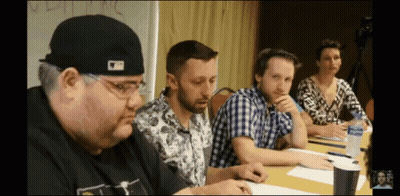 A Man Wearing A Hat That Says ' Mlb ' On It Sits At A Table GIF
