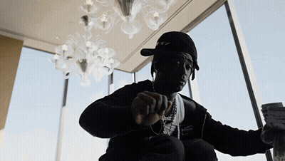 A Man Wearing A Hat That Says Ritz Is Holding A Stack Of Money GIF