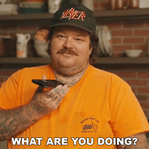 A Man Wearing A Hat That Says Slayer Is Holding A Phone And Asking What Are You Doing GIF