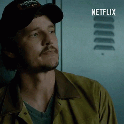 A Man Wearing A Hat That Says ' Stanford ' On It Stands In Front Of A Netflix Logo GIF