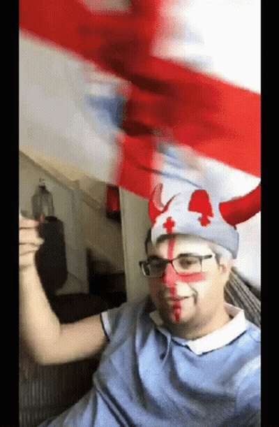 A Man Wearing A Hat With Horns And A Red Cross On It GIF