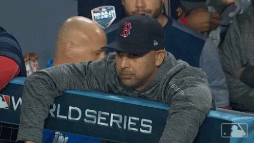 A Man Wearing A Hat With The Letter B On It Sits In The Dugout GIF