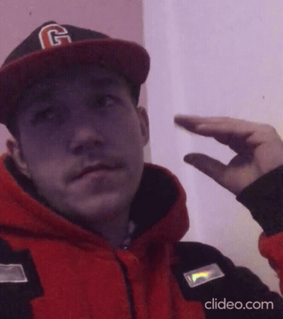 A Man Wearing A Hat With The Letter G On It Is Making A Hand Gesture GIF