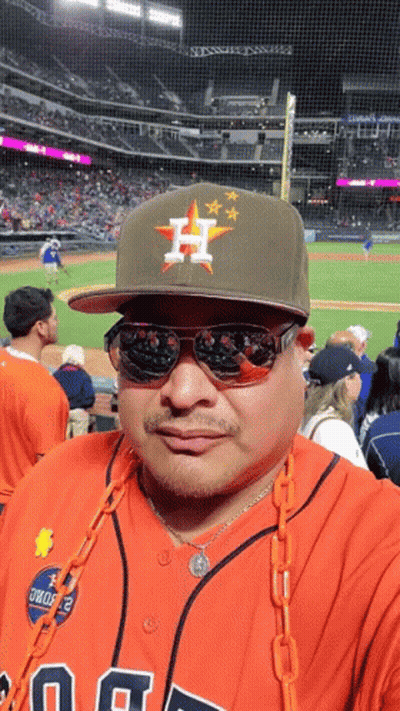 A Man Wearing A Hat With The Letter H On It Stands In Front Of A Baseball Field GIF