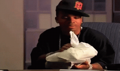 A Man Wearing A Hat With The Letter R On It Is Sitting At A Table Holding A Piece Of Paper . GIF
