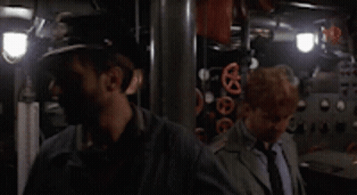 A Man Wearing A Hat With The Letter R On It Is Standing Next To Another Man GIF