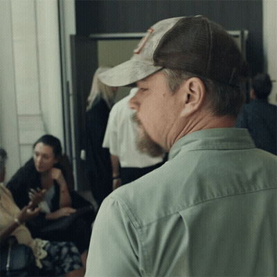 A Man Wearing A Hat With The Letter R On It Looks To His Left GIF