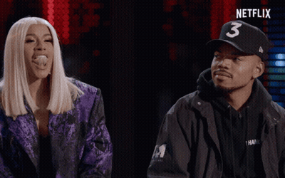 A Man Wearing A Hat With The Number 3 On It Stands Next To A Woman In A Purple Jacket GIF