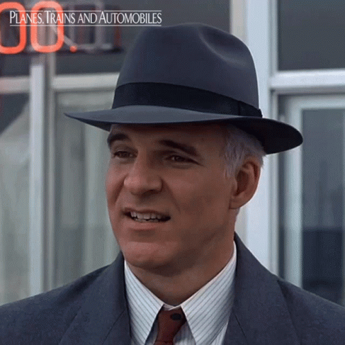 A Man Wearing A Hat With The Words Planes Trains And Automobiles On The Bottom Right GIF