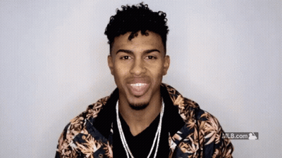 A Man Wearing A Hawaiian Jacket Is Smiling In Front Of A Mlb.com Logo GIF