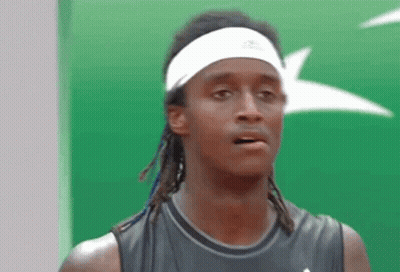 A Man Wearing A Headband And A Black Tank Top Looks At The Camera GIF