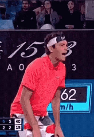 A Man Wearing A Headband And A Red Shirt Is Playing Tennis . GIF