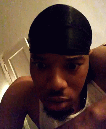 A Man Wearing A Headband And A Tank Top Looks At The Camera GIF