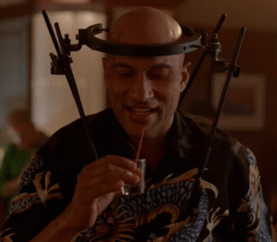 A Man Wearing A Headband And Glasses Is Eating Something GIF