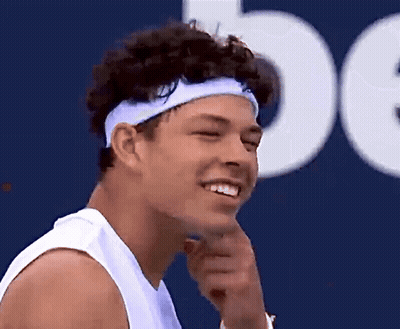 A Man Wearing A Headband Is Smiling And Looking To The Side GIF