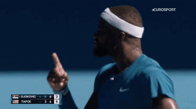 A Man Wearing A Headband Is Smiling On A Tennis Court GIF