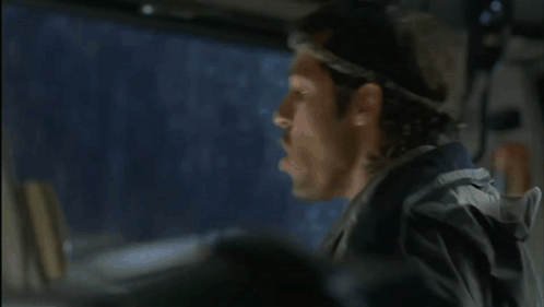 A Man Wearing A Headband Looks Out The Window Of A Car GIF