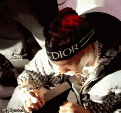 A Man Wearing A Headband That Says Dior Is Holding A Microphone . GIF