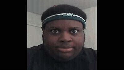 A Man Wearing A Headband With The Eagles Logo On It Looks At The Camera . GIF